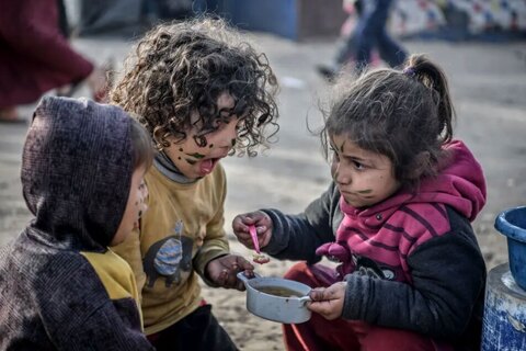 کودکان فلسطینی در حال خوردن یک وعده غذای گرم